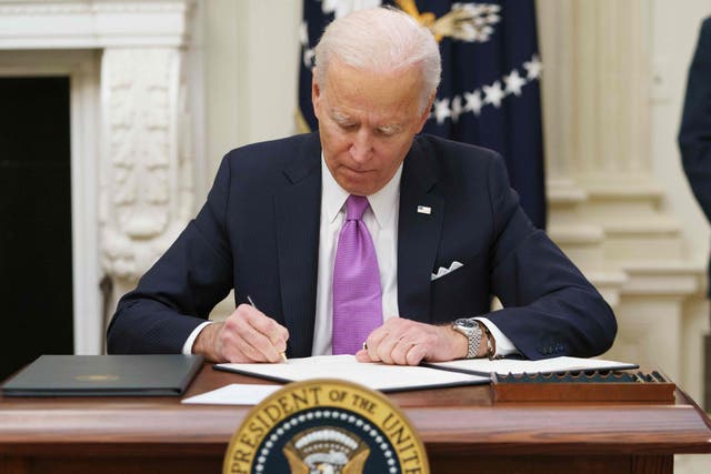 <p>Joe Biden signs executive orders as part of the Covid-19 response in the State Dining Room of the White House in Washington</p>