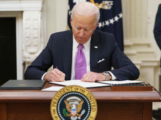 <p>Joe Biden signs executive orders as part of the Covid-19 response in the State Dining Room of the White House in Washington</p>