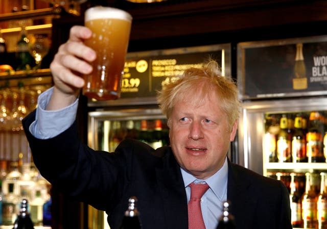 Boris Johnson, a leadership candidate for Britain's Conservative Party holds a pint of beer as he meets with JD Wetherspoon chairman, Tim Martin at  Wetherspoons Metropolitan Bar on July 10, 2019 in London, England