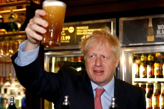 Boris Johnson, a leadership candidate for Britain's Conservative Party holds a pint of beer as he meets with JD Wetherspoon chairman, Tim Martin at  Wetherspoons Metropolitan Bar on July 10, 2019 in London, England