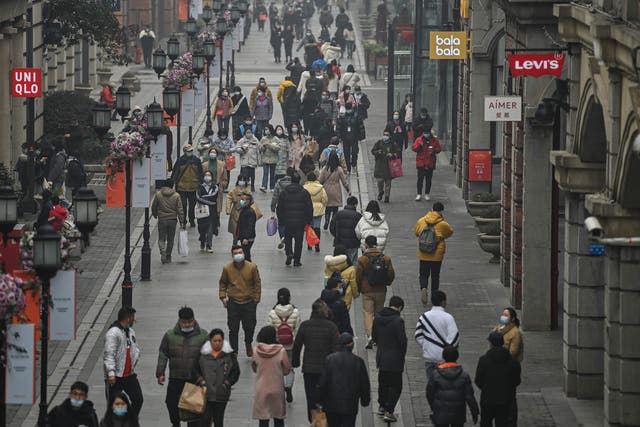 <p>People walking along a pedestrian street in Wuhan on 23 January, 2021, one year after the city went into lockdown to curb the spread of Covid-19</p>