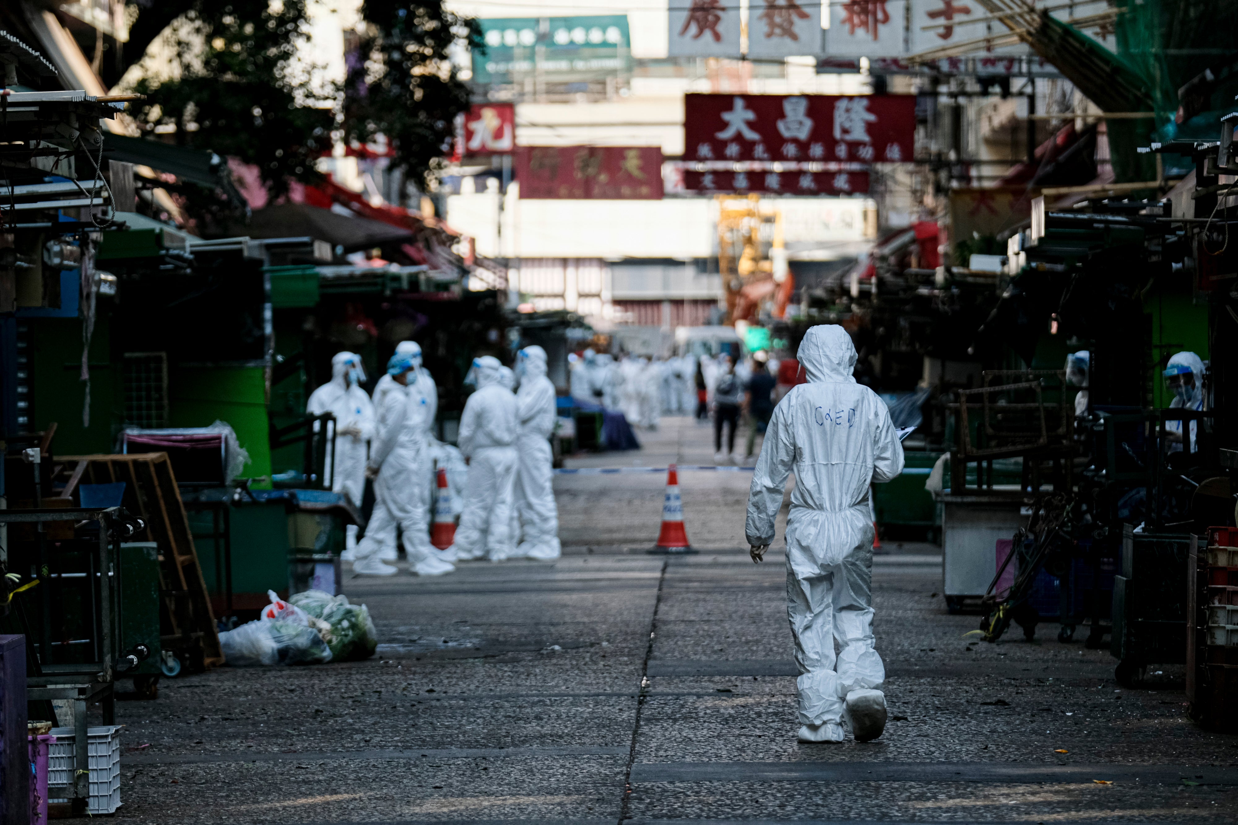 Government workers wear personal protective equipment inside the lockdown area in Jordon district in Hong Kong