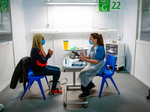Immunisation Nurse Debbie Briody (R) fills in forms prior to administering the Pfizer/BioNtech Covid-19 vaccine to Staff Nurse Amanda Thompson at the NHS Louisa Jordan temporary hospital at the SEC Campus in Glasgow