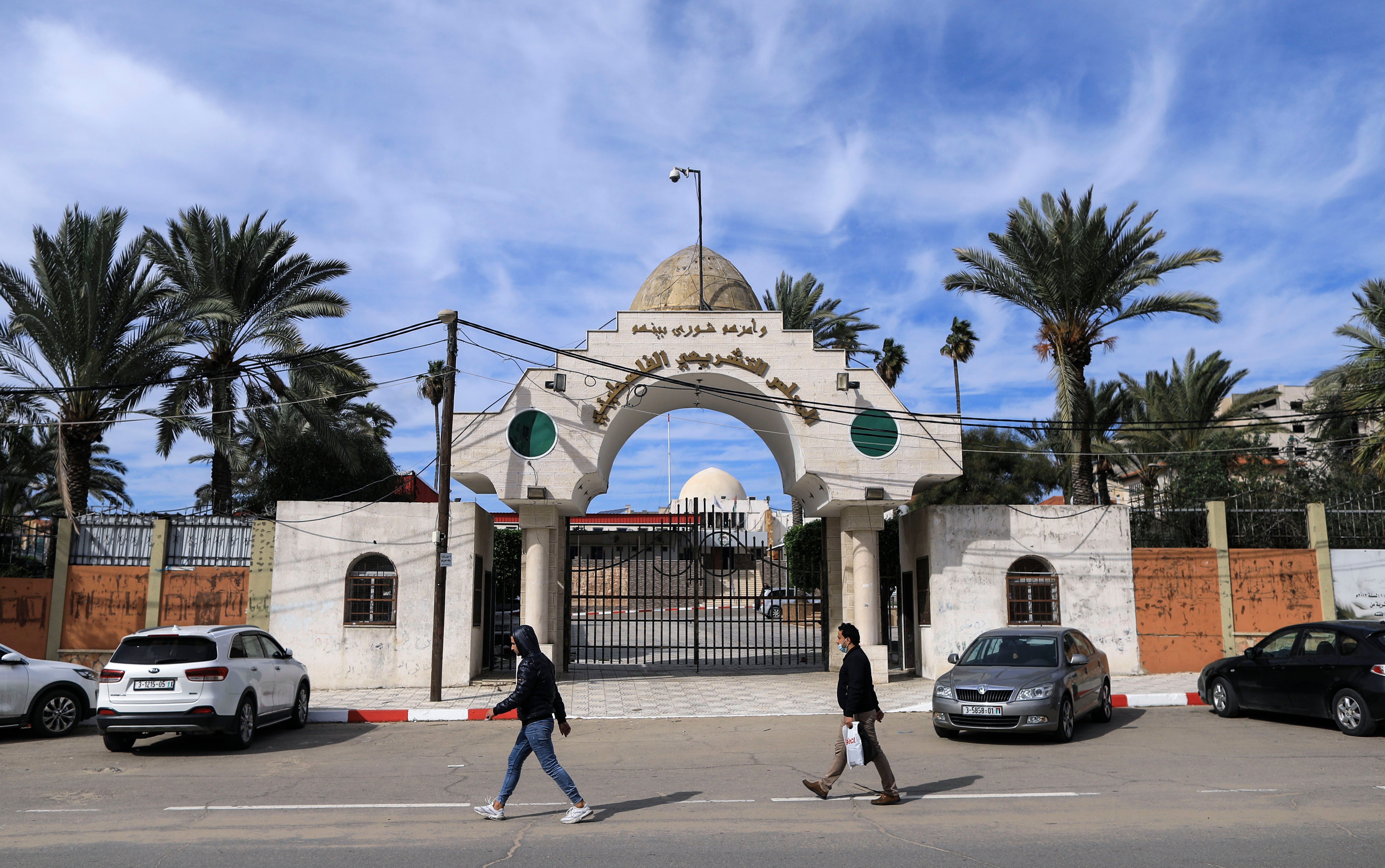 Palestinians walk past the entrance of the Legislative Council building in Gaza City, on 17 January, 2021. The UN has called on Israel to swiftly provide vaccines to Palestinians living in occupied territories.