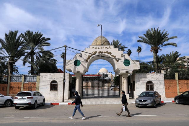 Palestinians walk past the entrance of the Legislative Council building in Gaza City, on 17 January, 2021. The UN has called on Israel to swiftly provide vaccines to Palestinians living in occupied territories.