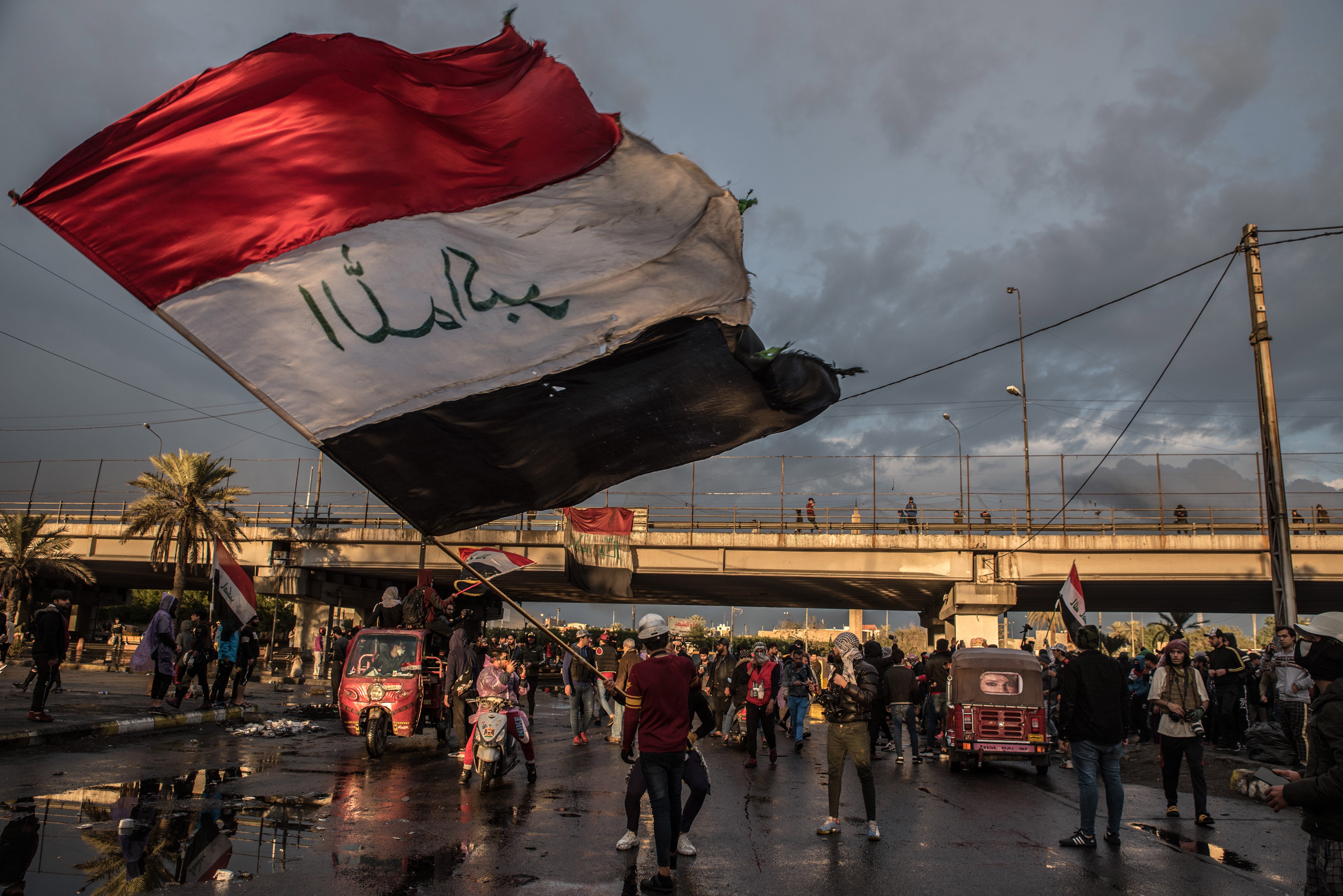 A man waves the Iraqi flag in Baghdad in January 2020 during a symbolic ‘funeral’ for a protester killed in clashes with security forces