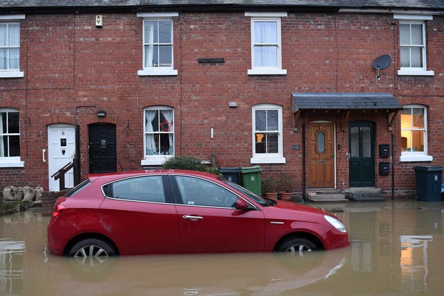 Floodwaters surrounds a car parked outside a row of houses in Shrewsbury, western England, on 22 January 2021 after Storm Christoph brought heavy rains and flooding across the country