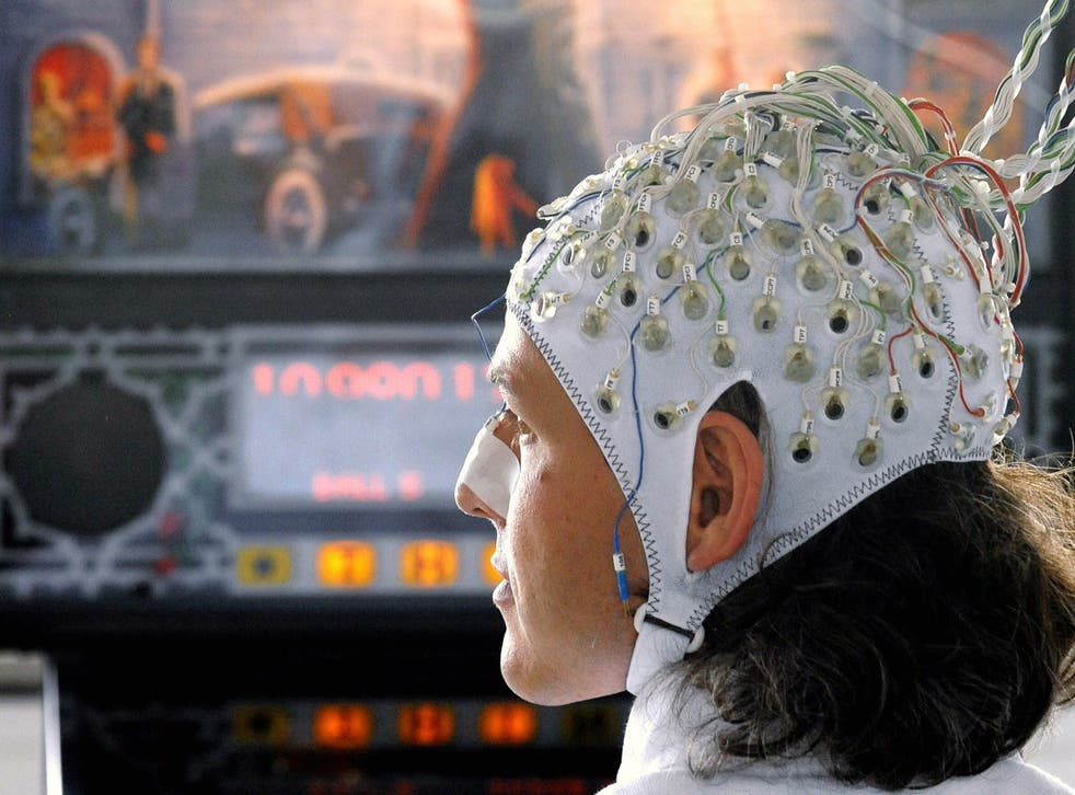 A researcher operates a pinball machine via electrodes attached to his head in an early demonstration of brain-computer interface technology on 4 June, 2009 in Berlin