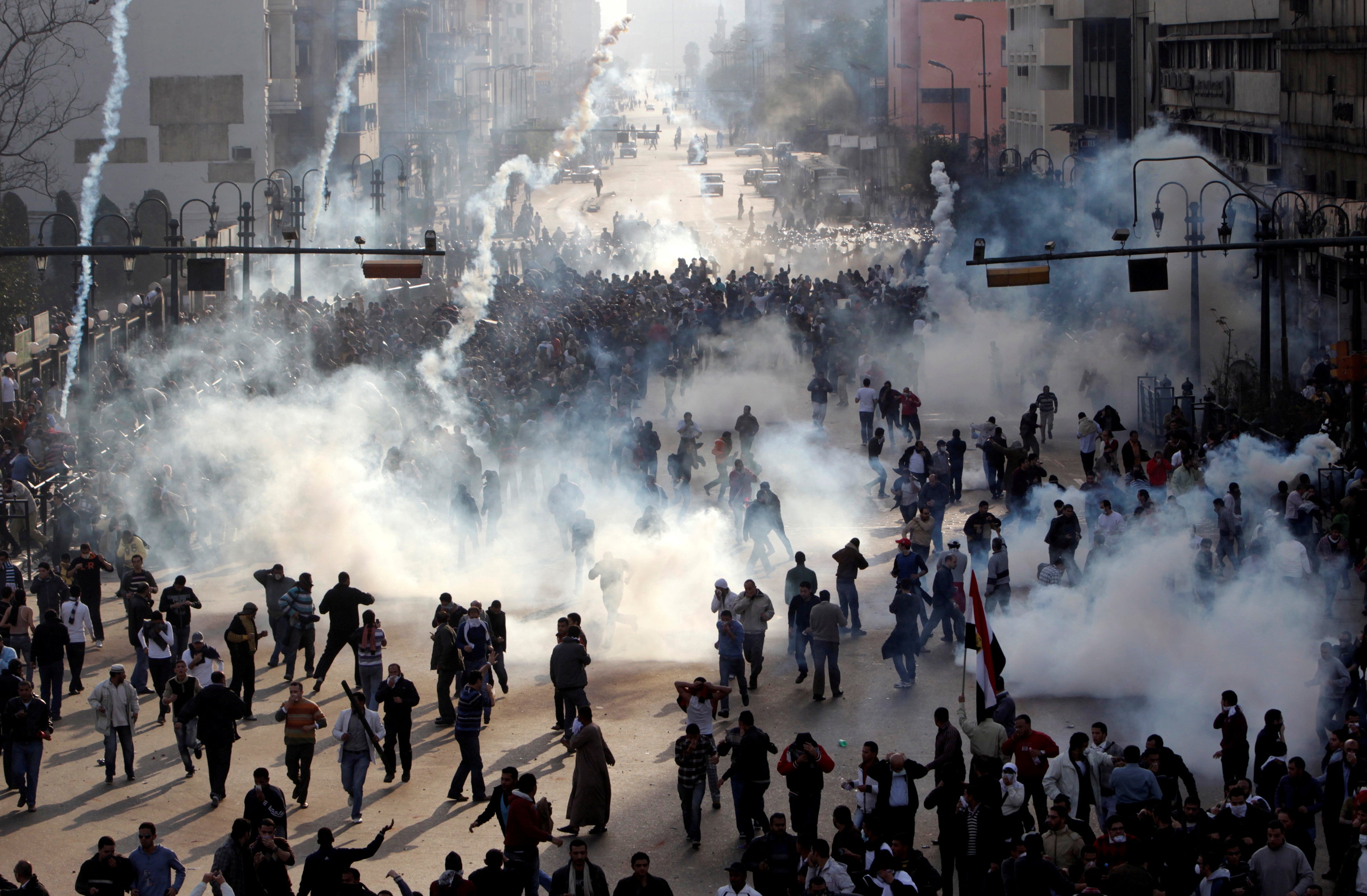 Protesters flee from tear gas fire during clashes in Cairo