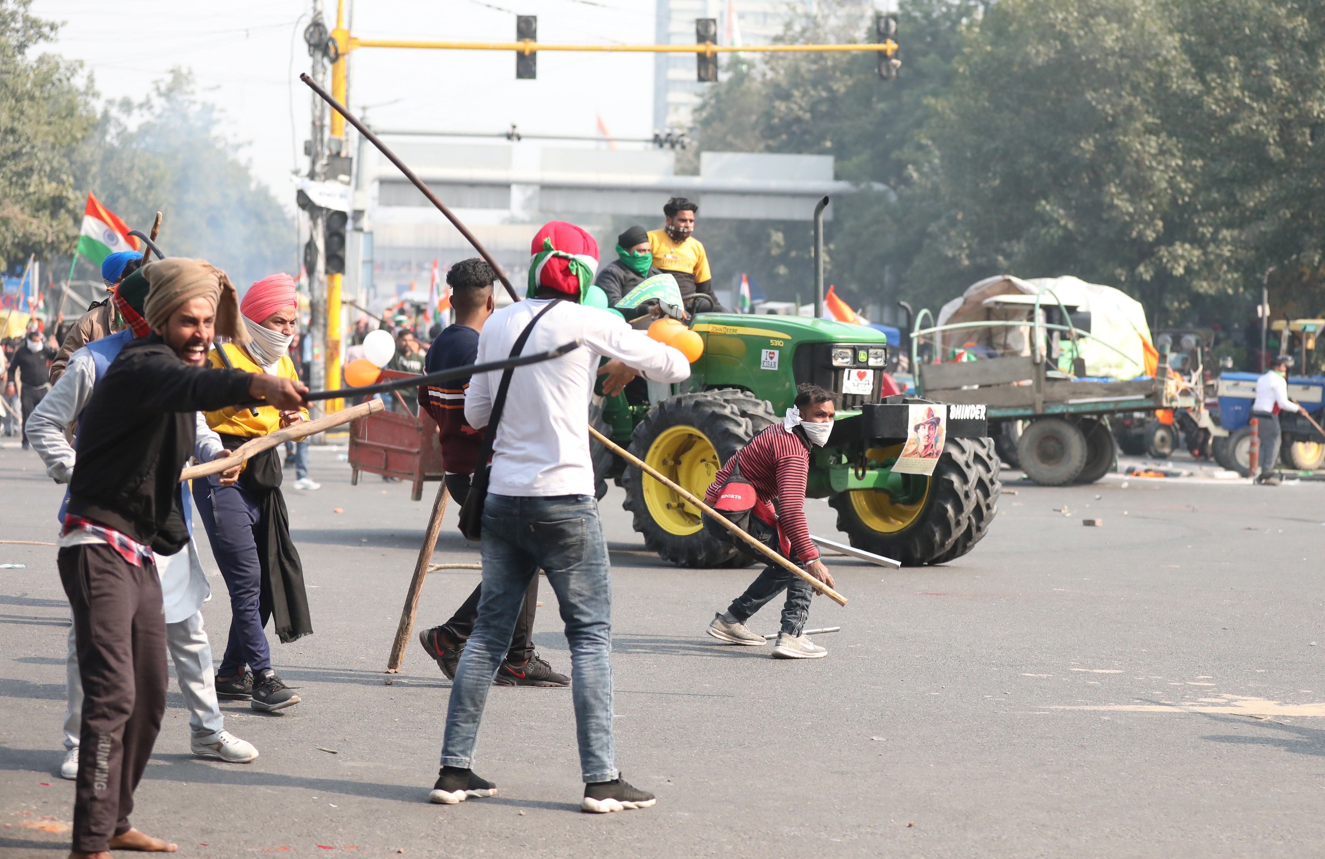 Farmers hold sticks as they confront police officers in Delhi