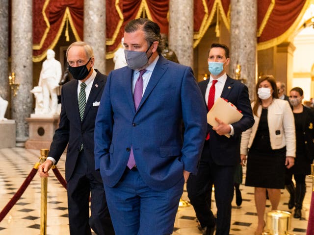 Ted Cruz, al frente, seguido por Josh Hawley, camina desde la Cámara de la Cámara luego de una procesión del Senado con cajas con votos del Colegio Electoral a la Cámara de la Cámara para una sesión conjunta para confirmar los votos del Colegio Electoral, el miércoles 6 de enero de 2021, en Washington.