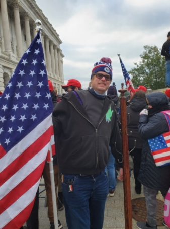 Dustin Thompson allegedly posing with a coat rack from the US Capitol, according to a Department of Justice affidavit