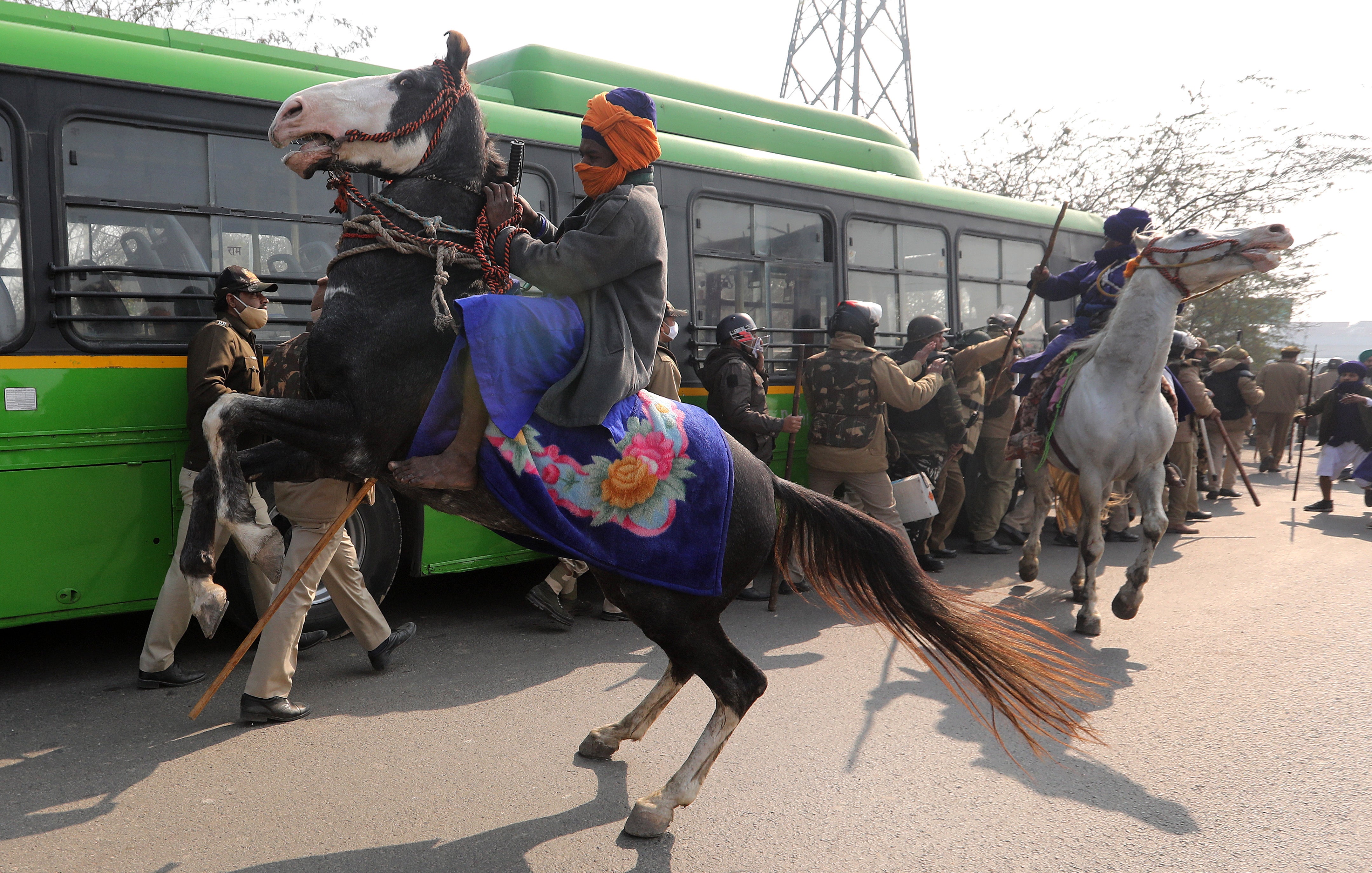 Men belonging to an armed Sikh order clash with police personnel as people take part in a ‘parallel parade’ on tractors and trolleys, during the ongoing farmers protest against new farm laws