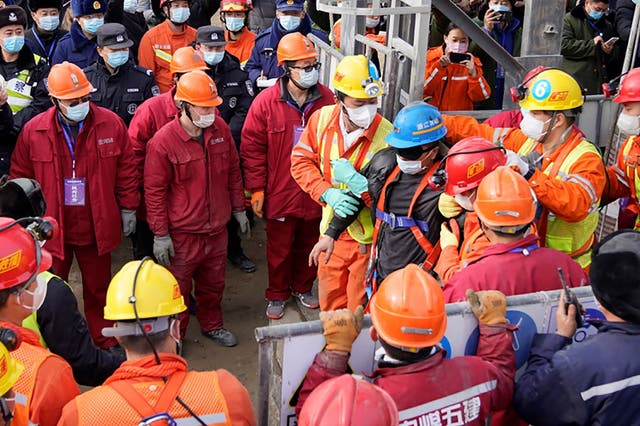 <p>One (blue helmet) of the 22 miners rescued from hundreds of metres underground in a gold mine in China&nbsp;</p>