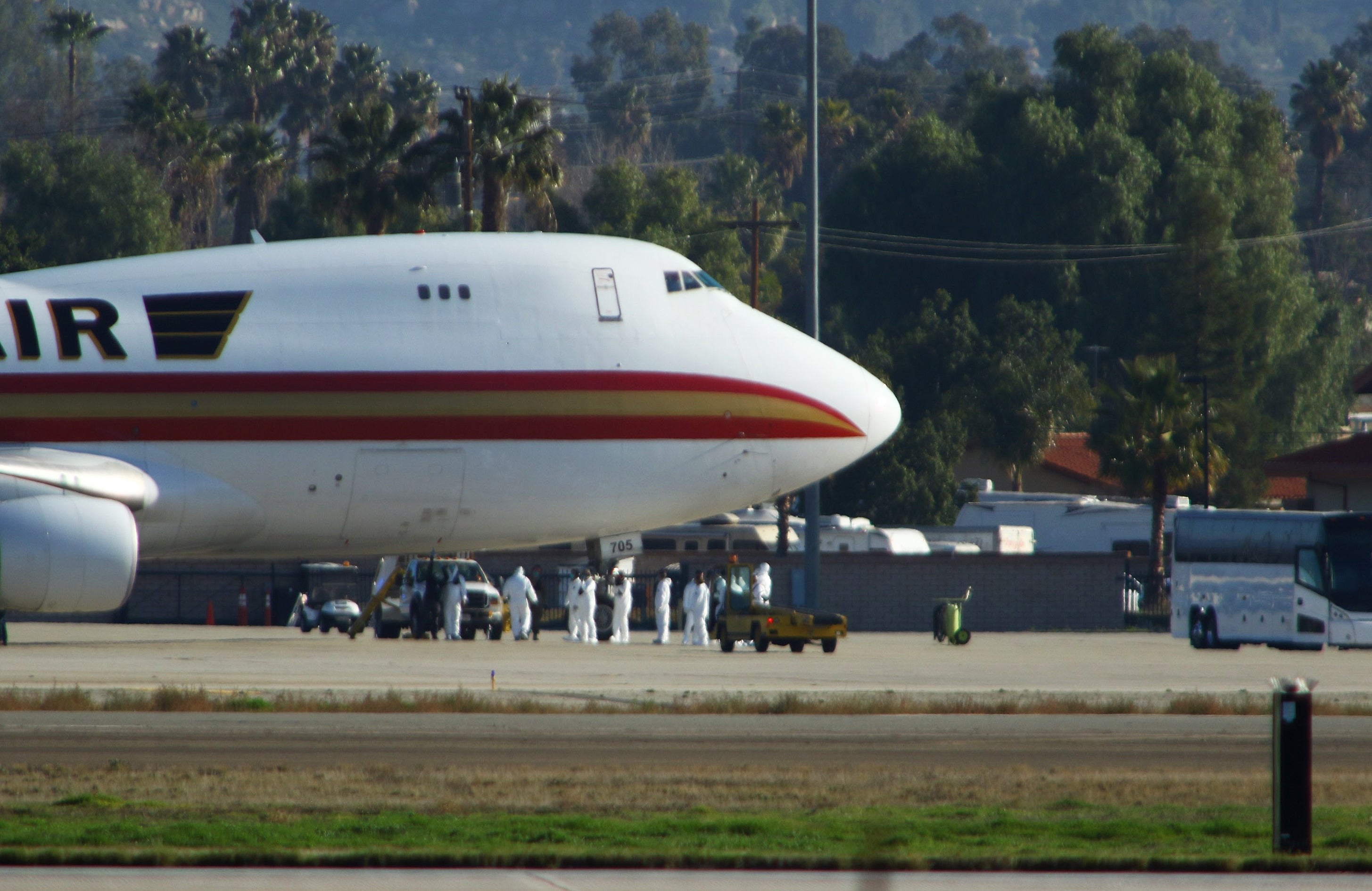 Personnel in biological hazard suits await passengers evacuated from Wuhan, the Chinese city at the heart of a growing outbreak of the deadly 2019 Novel Coronavirus shortly after the plane landed at March Air Reserve Base in Riverside, California on 29 January, 2020. A year later, a federal investigation has found the US government’s handling of evacuees from Wuhan likely put the American public’s health at further risk.