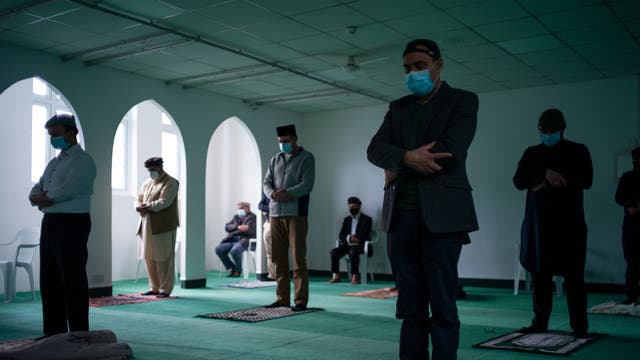 Members of the Ahmadiyya Muslim Community take part in Friday prayers at the Baitus Subhan Mosque in Croydon, England. For nearly the past year, the Covid-19 pandemic, and its resulting limits on public gatherings, have forced religious communities to find new ways to observe prayers, with many events being marked at home. Mosques as well as other places of religious worship remain open, though numbers have been limited to help maintain social distancing