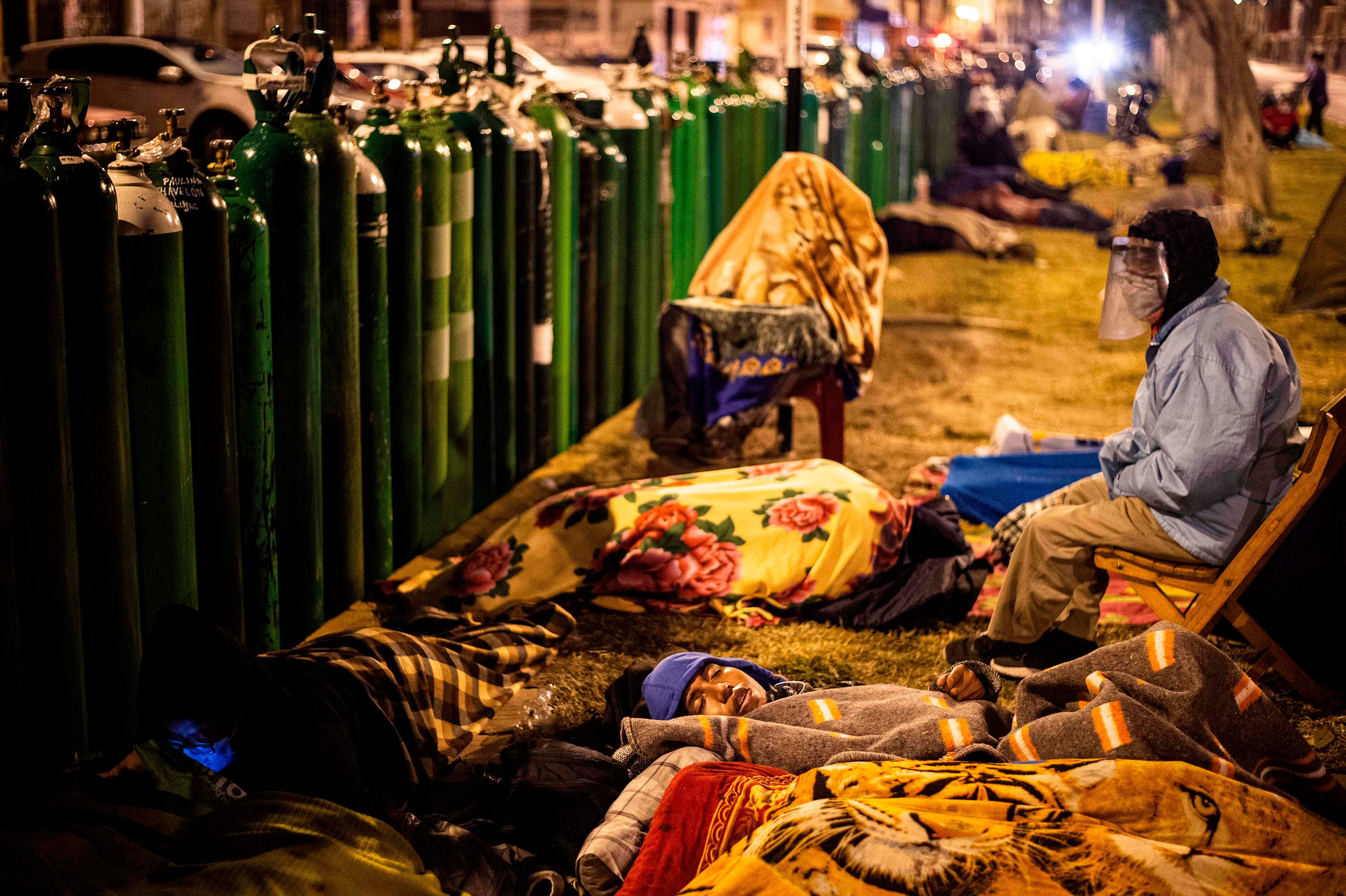 La gente hace cola para rellenar sus cilindros de oxígeno vacíos en Callao, Perú. Familiares de personas con COVID-19 están desesperados por oxígeno para mantener con vida a sus seres queridos en Perú, donde los pacientes han estado muriendo por falta de oxígeno