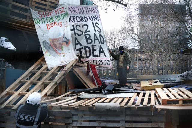 <p>A member of the eviction team speaks to an Extinction Rebellion activists who stands in a makeshift camp at Euston Station to protest against the HS2 high-speed railway</p>