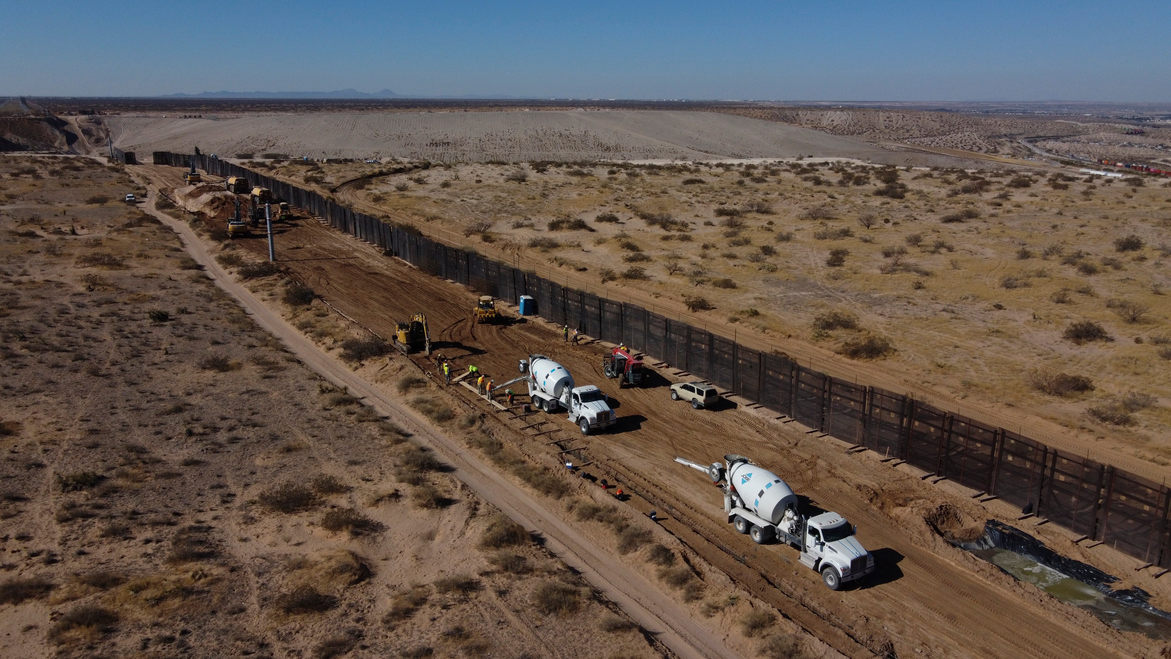 <p>Una cuadrilla de trabajadores preparando los cimientos de una sección de acero del muro fronterizo que se construirá en el lado mexicano de una antigua valla metálica que separa Ciudad Juárez, México, de Sunland Park, Nuevo México, en las afueras de Ciudad Juárez, en esta fotografía del martes 12 de enero de 2021.&nbsp;</p>