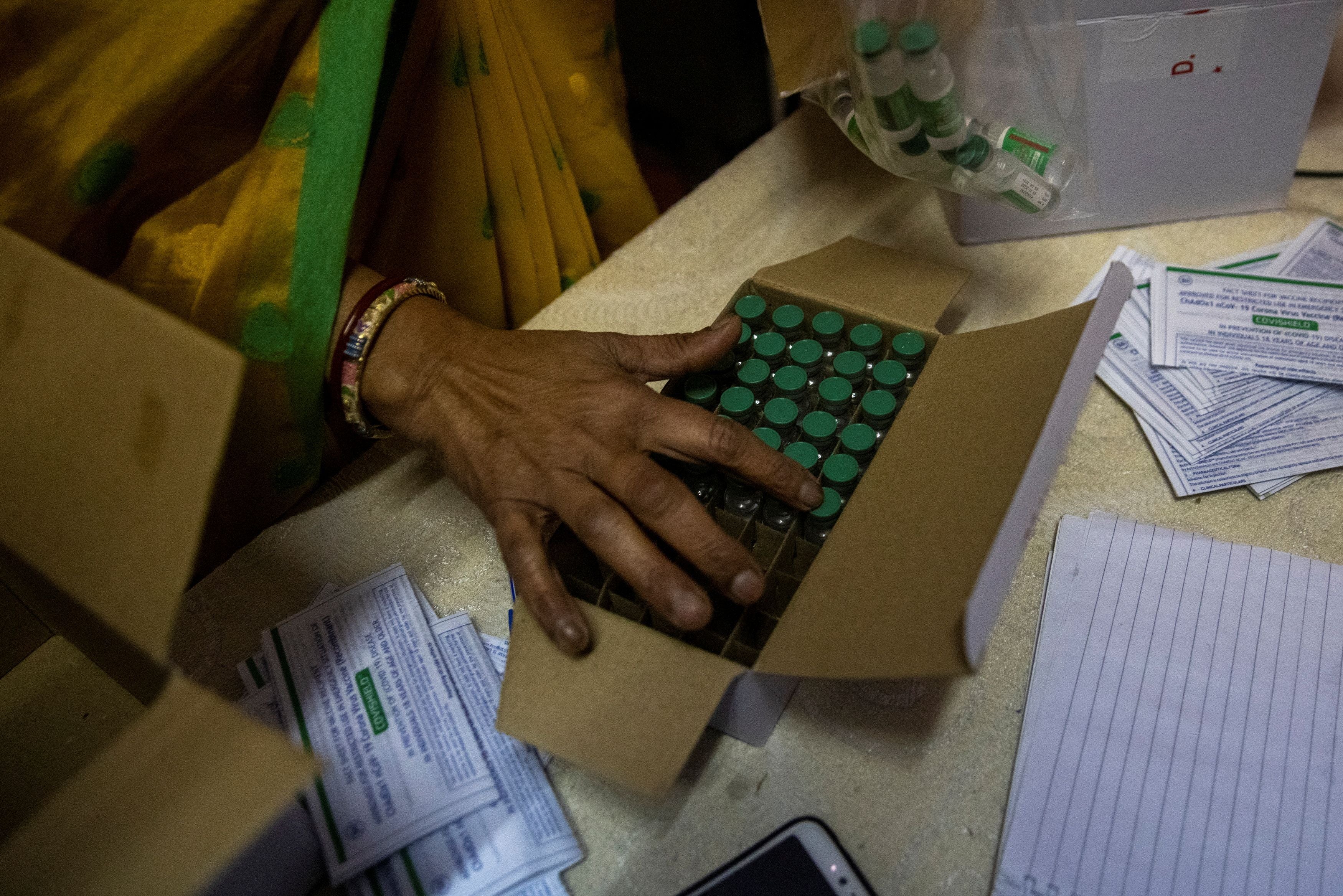 A health department employee counts vials of the vaccine