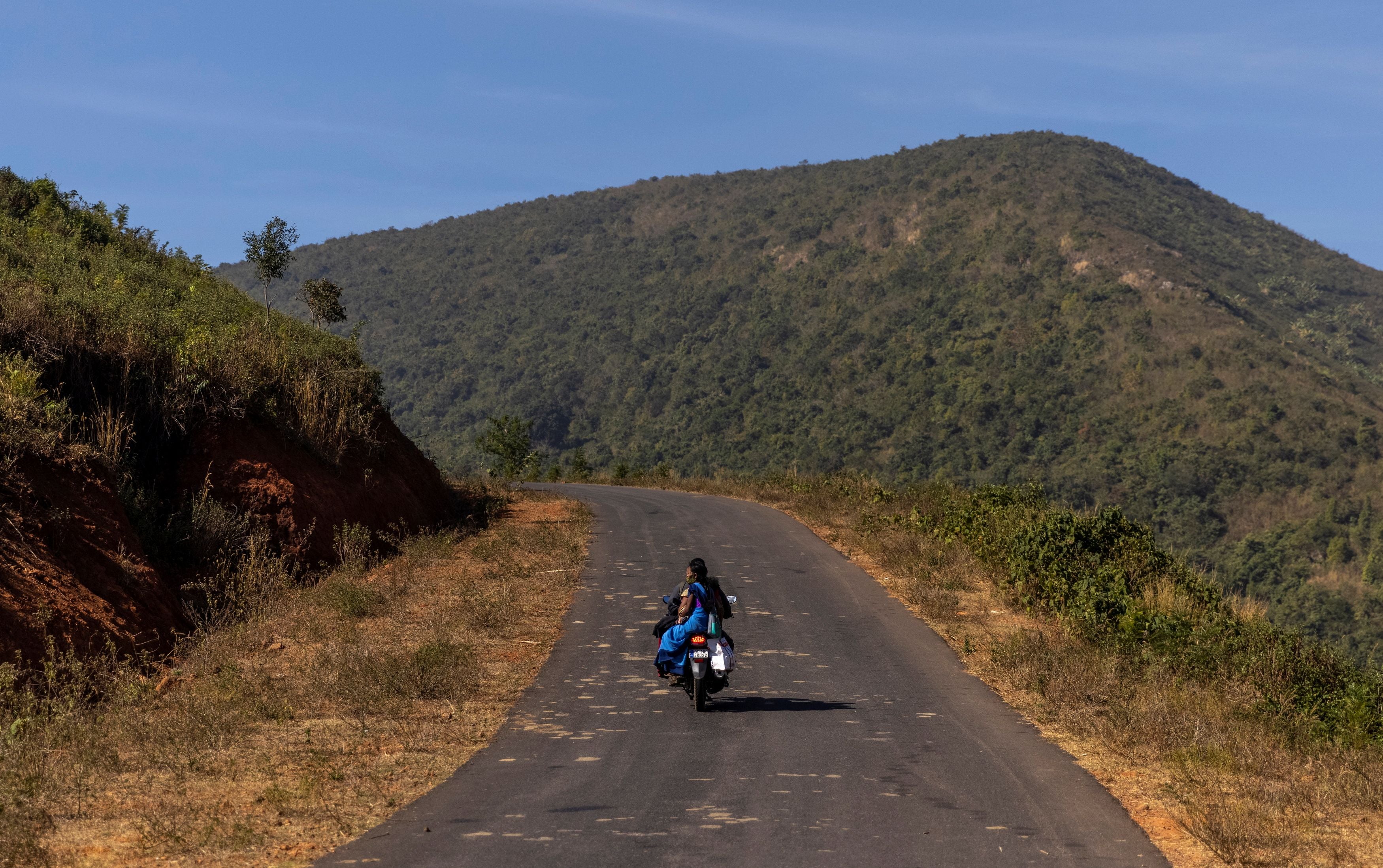 Reena Jani rides on her neighbour’s motorcycle as she travels to Mathalput Community Health Centre