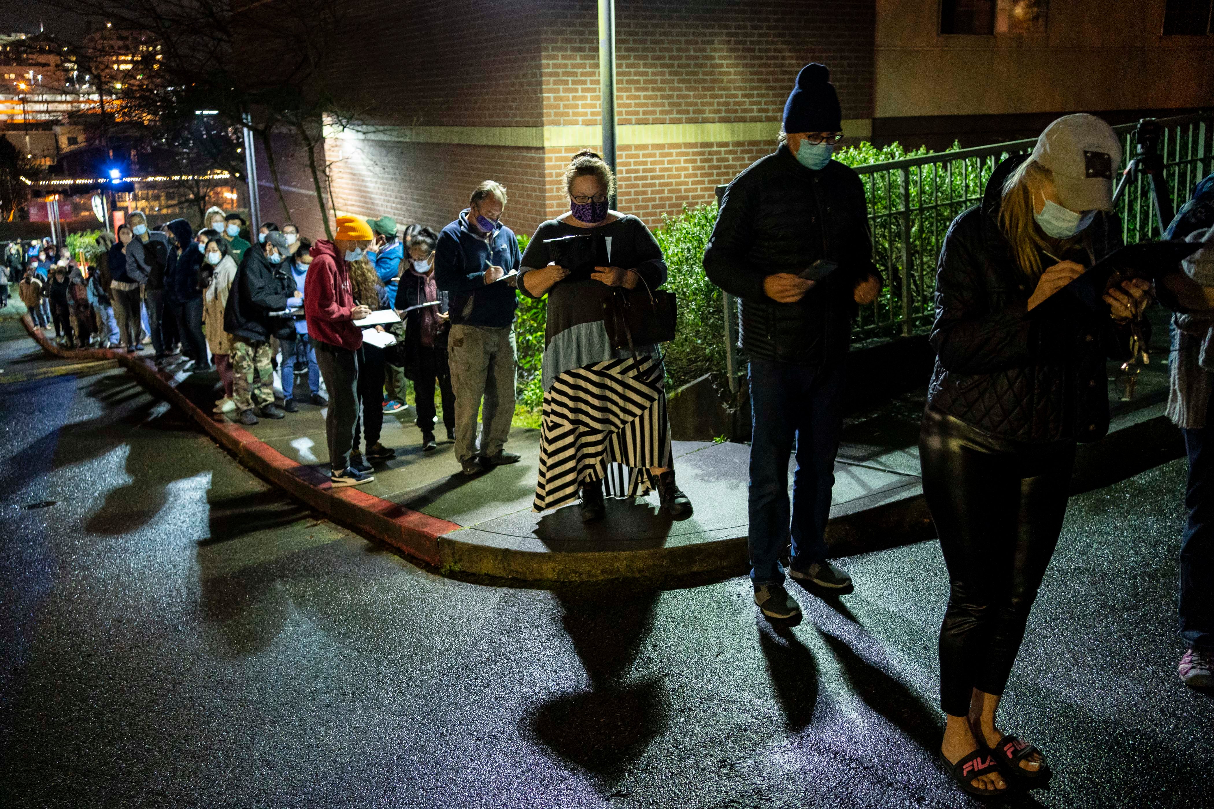 People wait in line for a last-minute COVID-19 vaccine event at Seattle University after a freezer failure at a nearby hospital on January 29, 2021 in Seattle, Washington. The impromptu overnight event was one of three in the city, organized late at night at two University of Washington vaccine clinics and one Swedish Health Services vaccine clinic, to ensure COVID-19 vaccine doses from an area hospital did not go to waste.