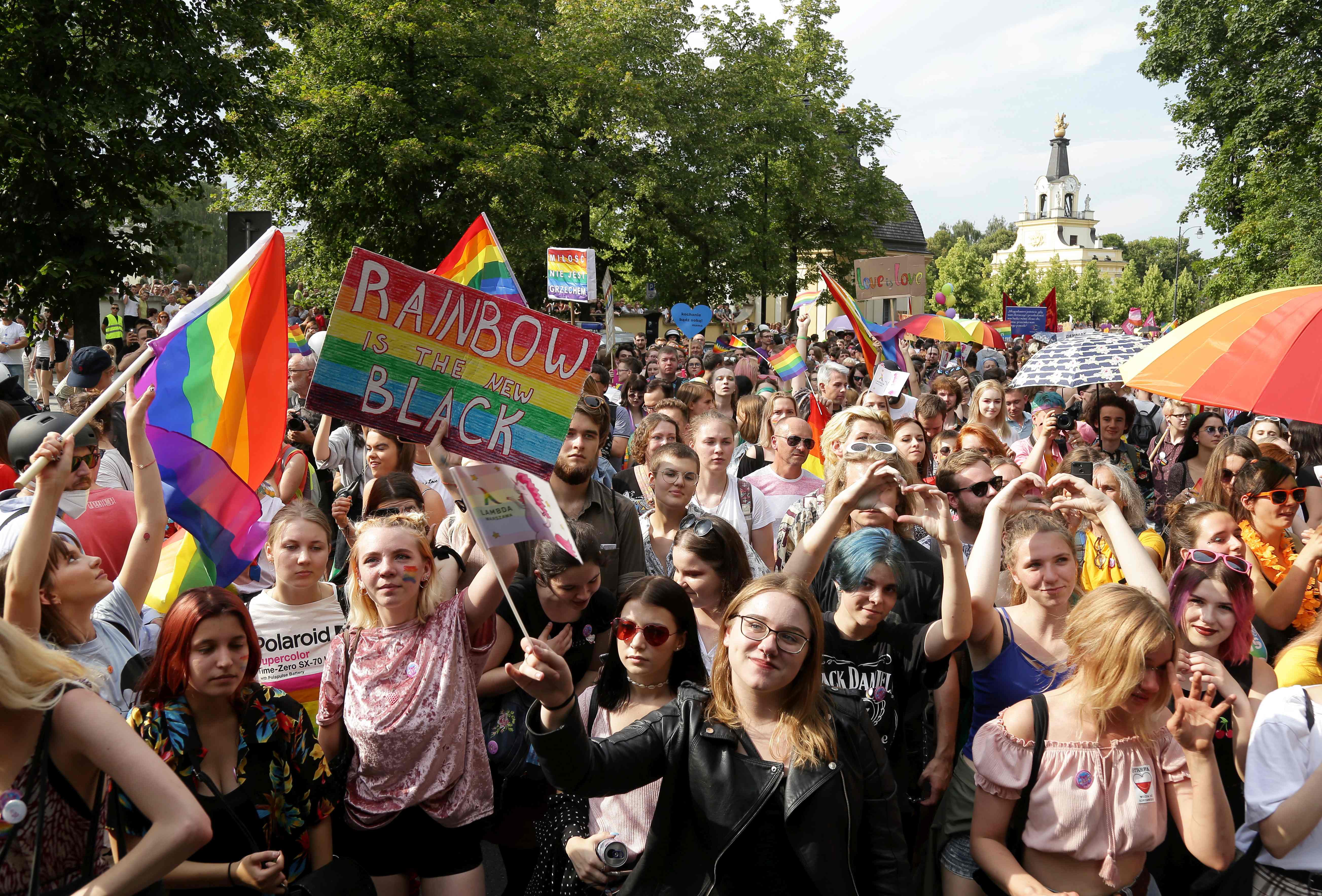 People hold flags and placards during the first gay pride march on July 20, 2019 in the city of Bialystok