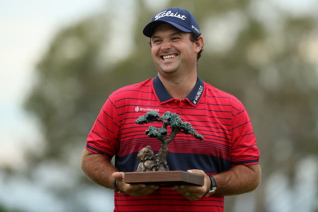 Patrick Reed celebrates with the trophy after winning the Farmers Insurance Open