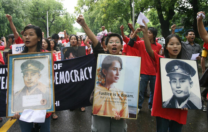 Myanmar protestors shout anti-military slogans as they display a portrait of Aung San Suu Kyi during a demonstration to mark the 20th anniversary of the 1988 pro-democracy revolution