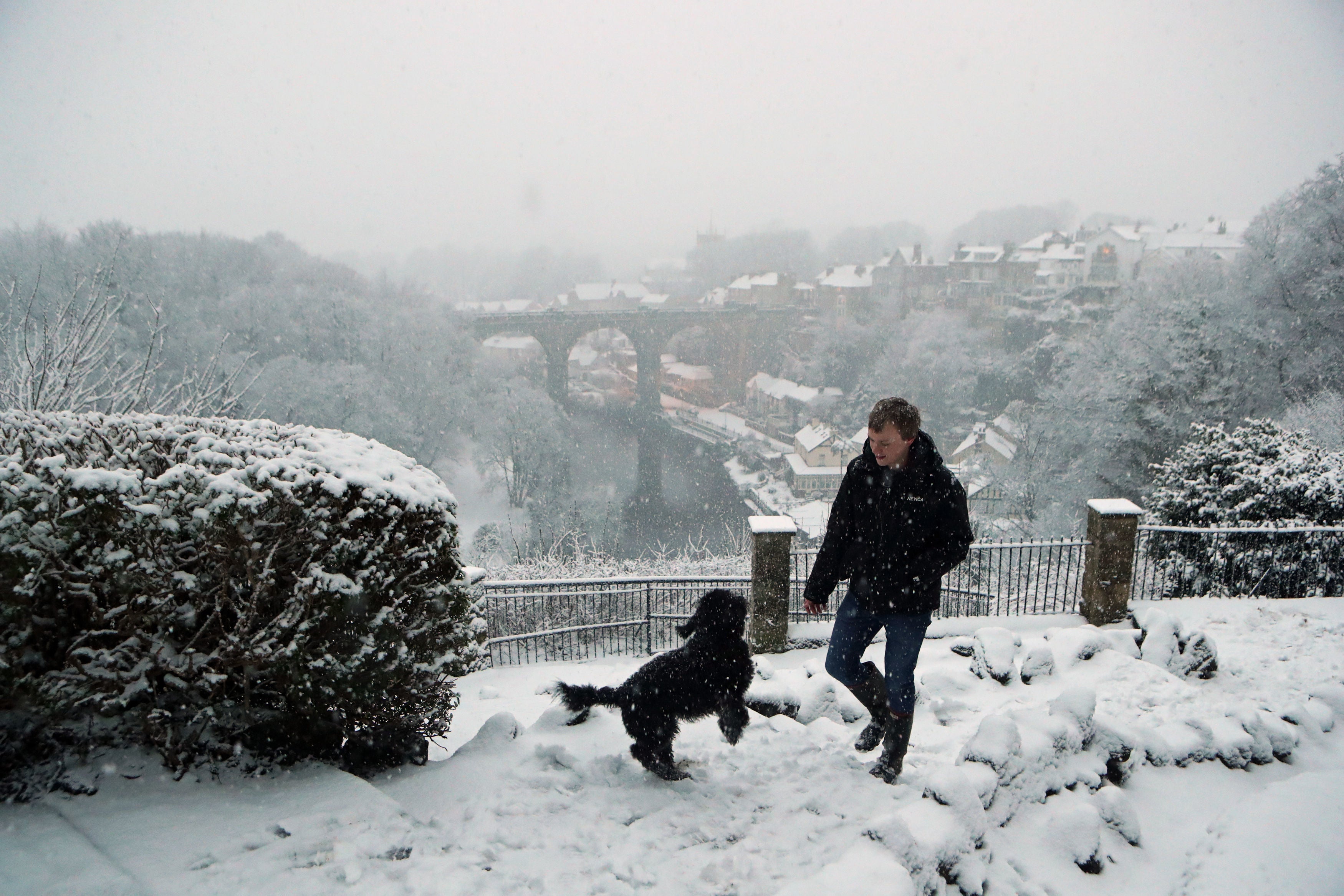 A man walks a dog in Knaresborough in North Yorkshire after snow fell overnight.