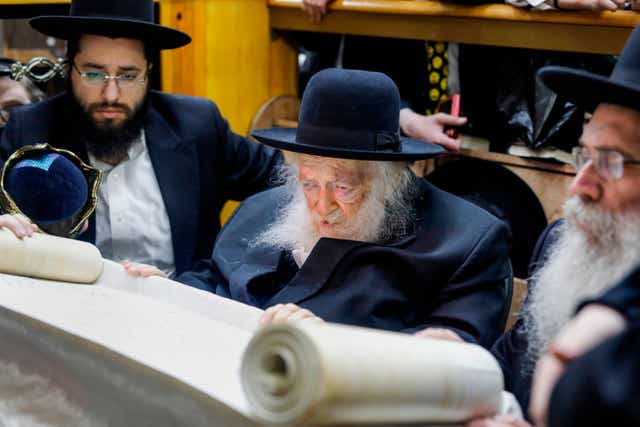 <p>On holiday: Rabbi Chaim Kanievsky reads the book of Esther in a rare visit to a local synagogue for the feast of Purim two years ago</p>