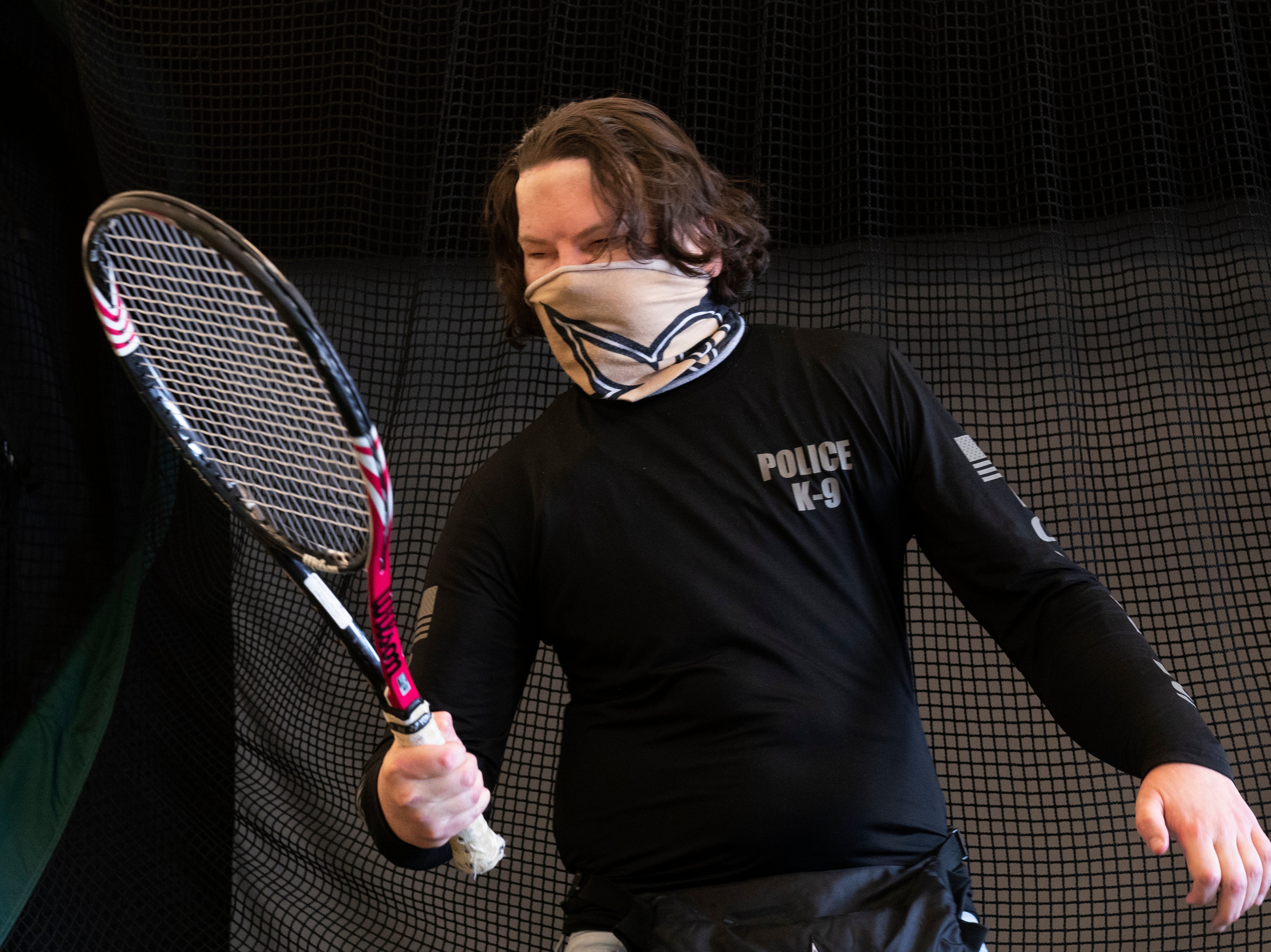 Joe DiMeo holds a tennis racket as he works in a physical therapy session
