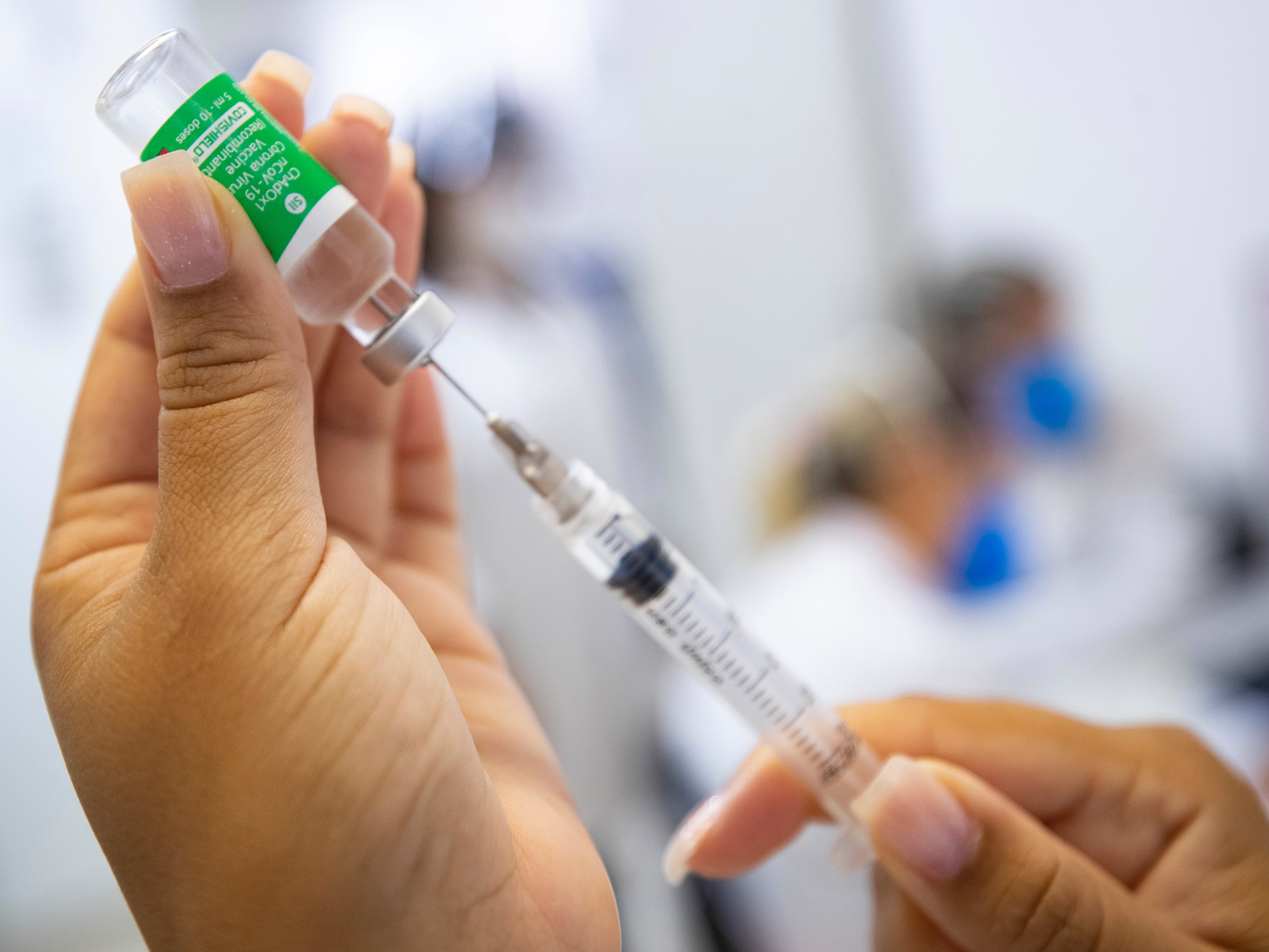 A nurse assistant prepares a dose of the AstraZeneca vaccine