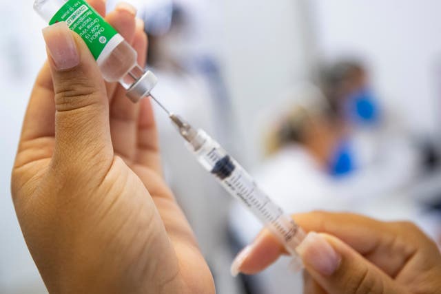 A nurse assistant prepares a dose of the AstraZeneca vaccine