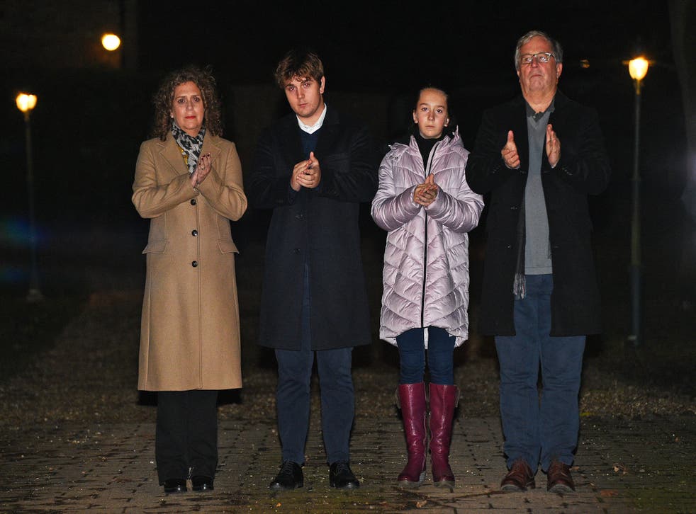 <p>Captain Tom’s daughter Hannah Ingram-Moore, grandson Benji, granddaughter Georgia and son-in-law Colin Ingram join in the clap outside his home in Marston Moretaine, Bedfordshire</p>