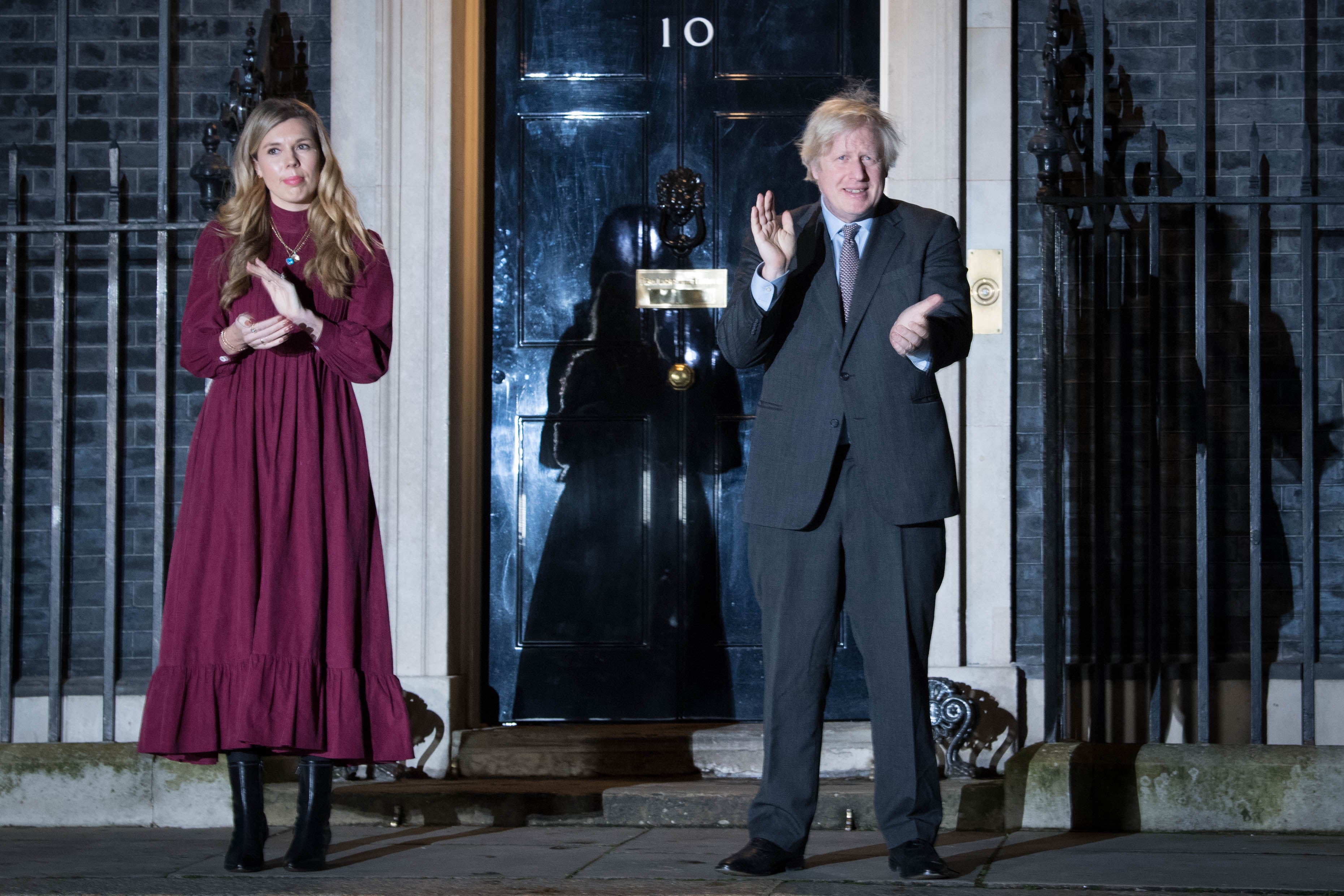 Boris Johnson and his partner Carrie Symonds clap outside 10 Downing Street on Wednesday