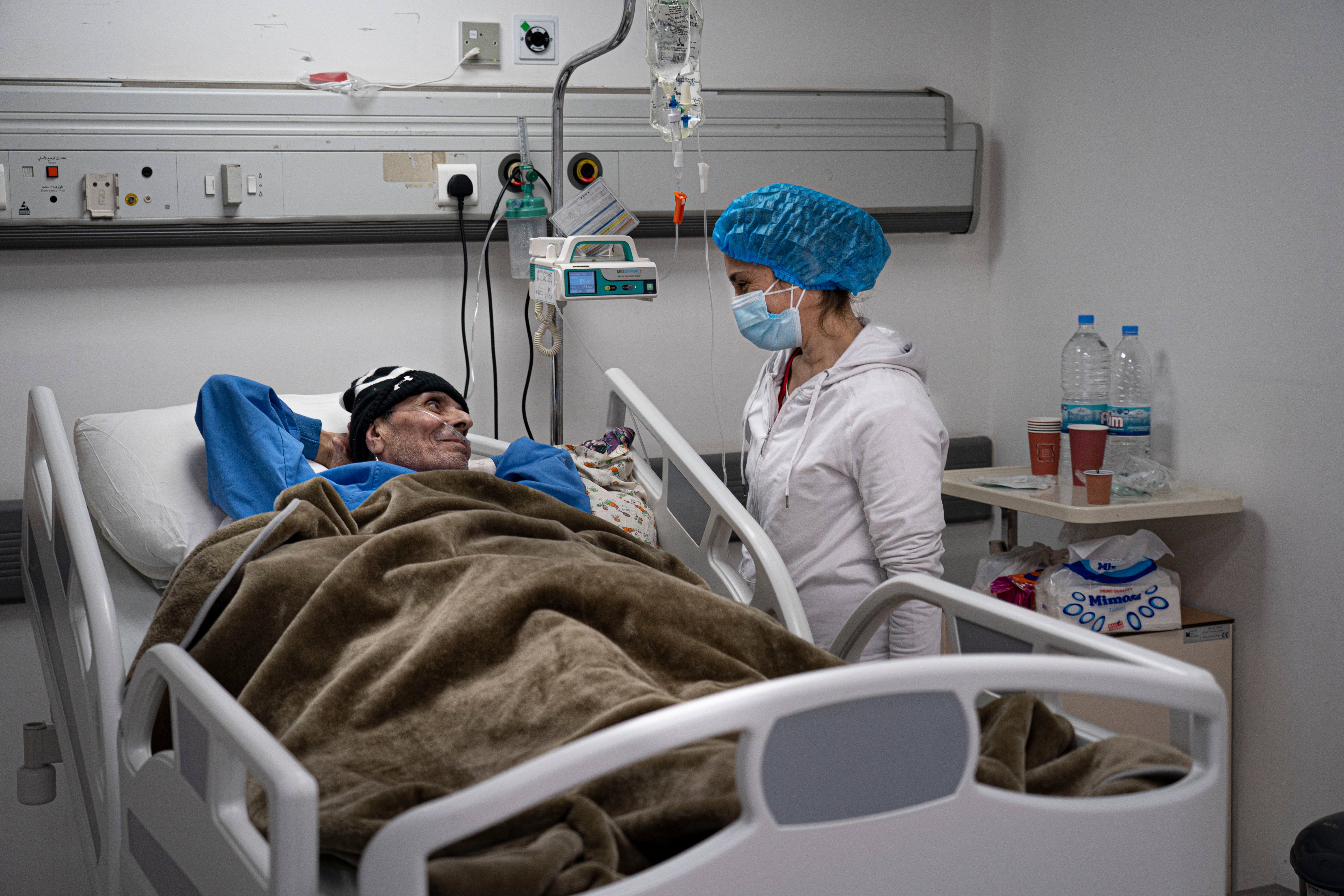 A nurse tends to her sick father in a coronavirus ward at the Rafic Hariri University Hospital