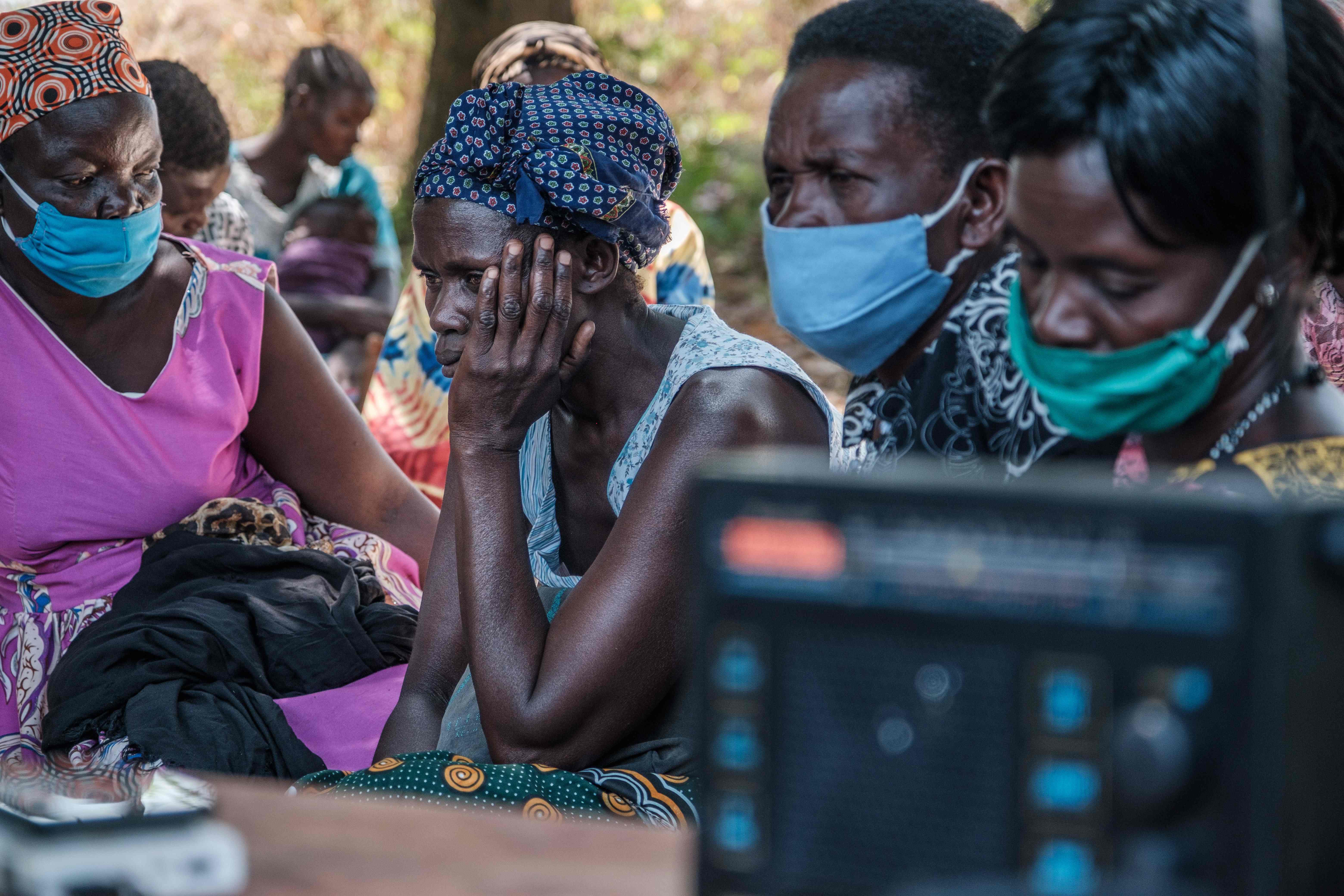 People from Lukodi gather around the radio to listen to the verdict on Dominic Ongwen