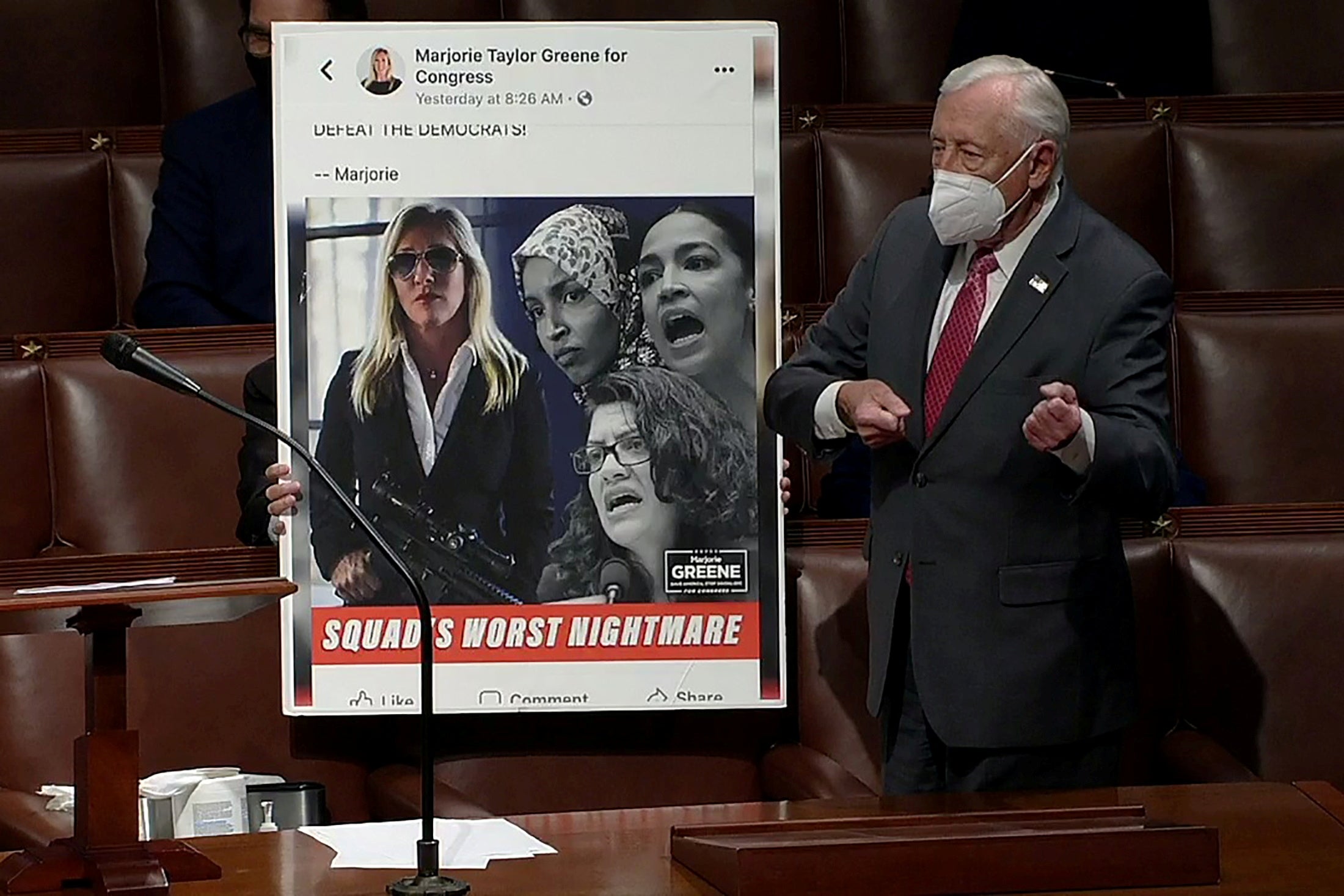 Steny Hoyer shows an enlarged picture showing Ms Greene holding a rifle next to an image of three Democratic congresswomen