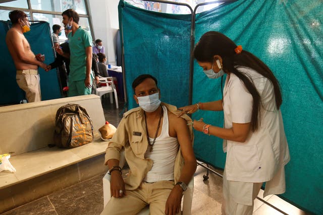 <p>A policeman receives a dose of Covid-19 vaccine at a vaccination centre in Ahmedabad, India</p>