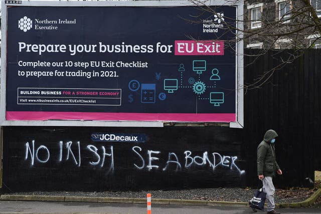  A man walks past graffiti in the loyalist Sandy row area, which reads ‘No Irish sea border’ under an EU Exit billboard on 30 January, 2021 in Belfast. The Police Service of Northern Ireland has been monitoring growing unionist discontent regarding the implementation of a so called Irish sea border