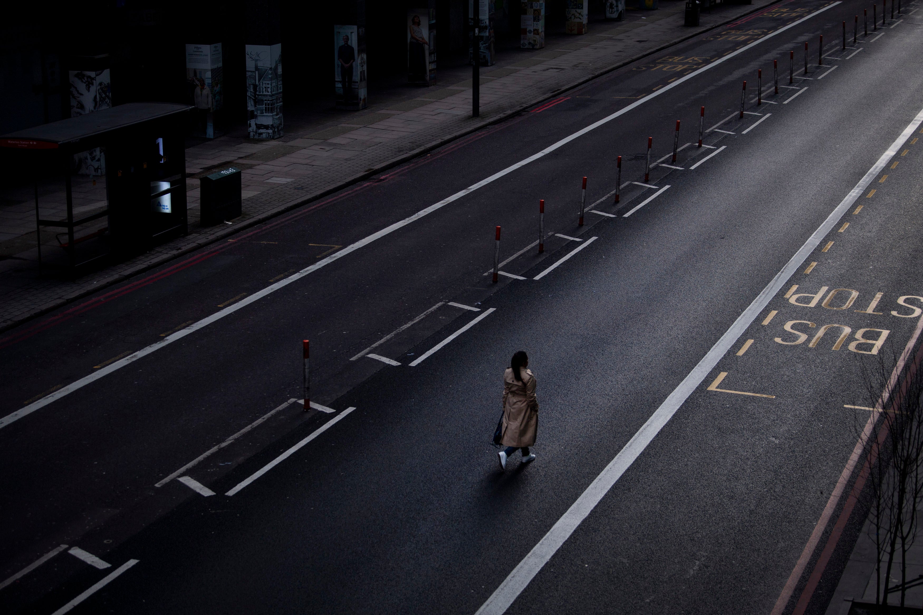 A lone woman walks down the middle of a main road in Westminster during England's third national lockdown to curb the spread of coronavirus