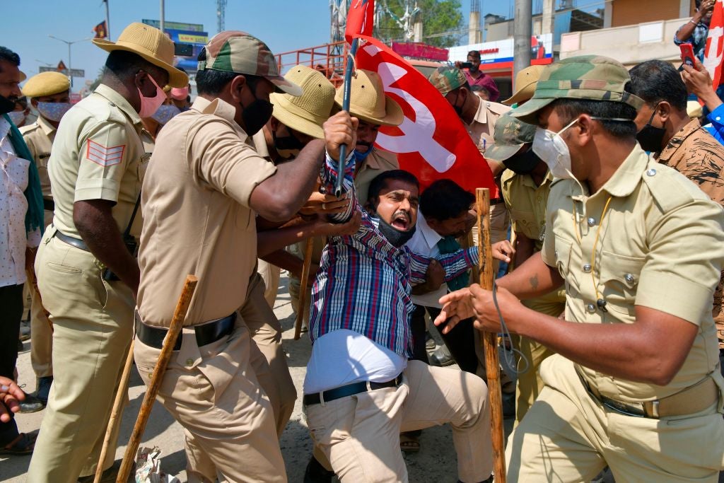 Police detain a farmer belonging to the Karnataka Rajya Raitha Sangha (KRRS), as he protests against the Indian government’s recent agricultural reforms