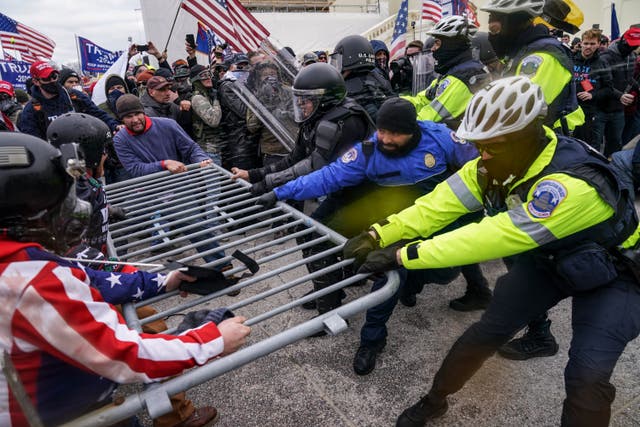 <p>Donald Trump supporters try to break through a police barrier at the Capitol in Washington</p>