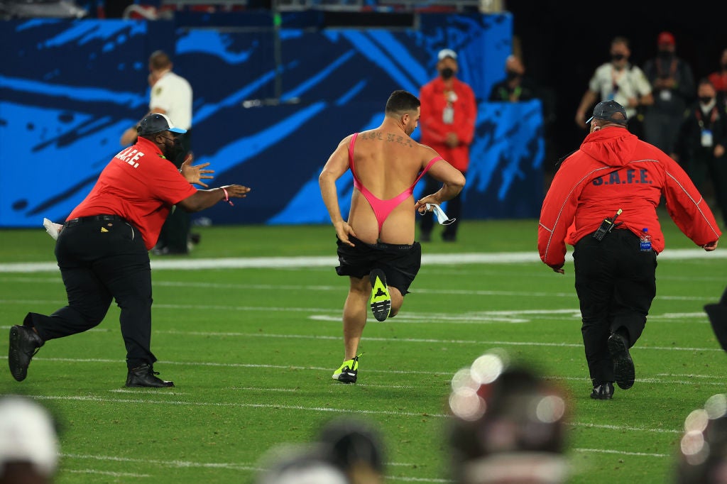 A fan runs on the field during the fourth quarter of Super Bowl LV