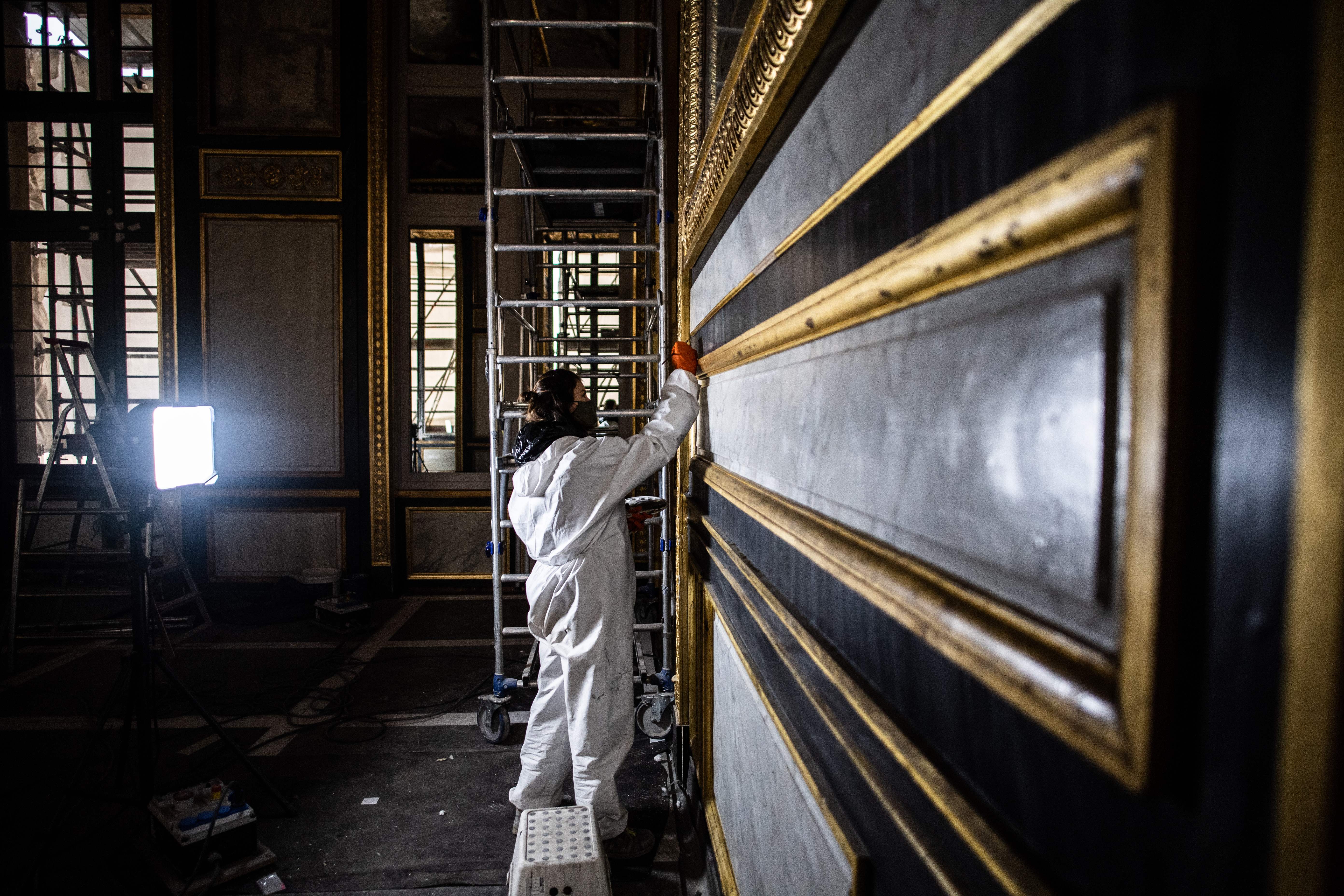 Broad brush: A decorator at the Louvre Museum, the world’s biggest, where visitors are down 70 per cent