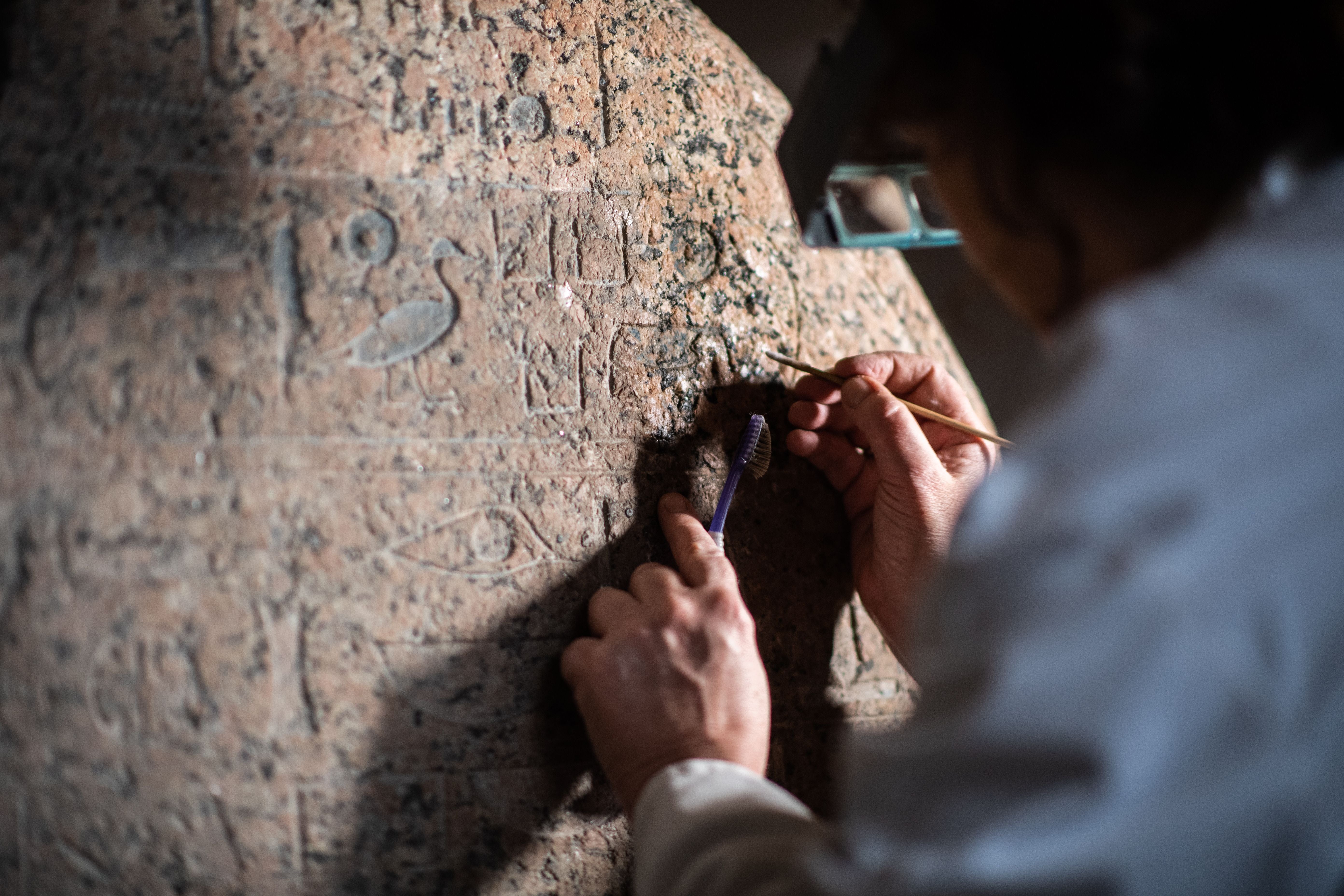 Restorer Sophie Duberson cleans the Egyptian funerary stele