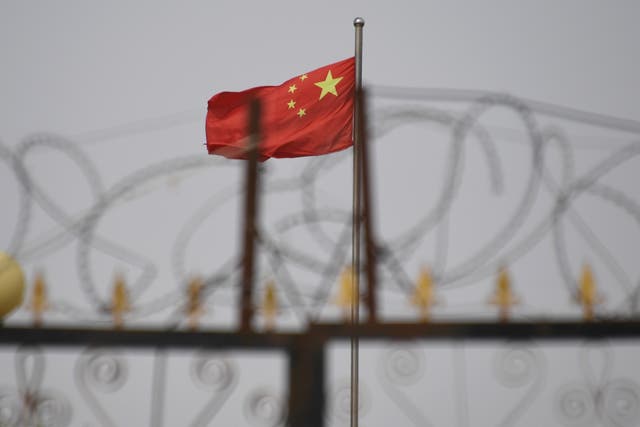 The Chinese flag behind razor wire at a housing compound in Yangisar, south of Kashgar, in China’s western Xinjiang region