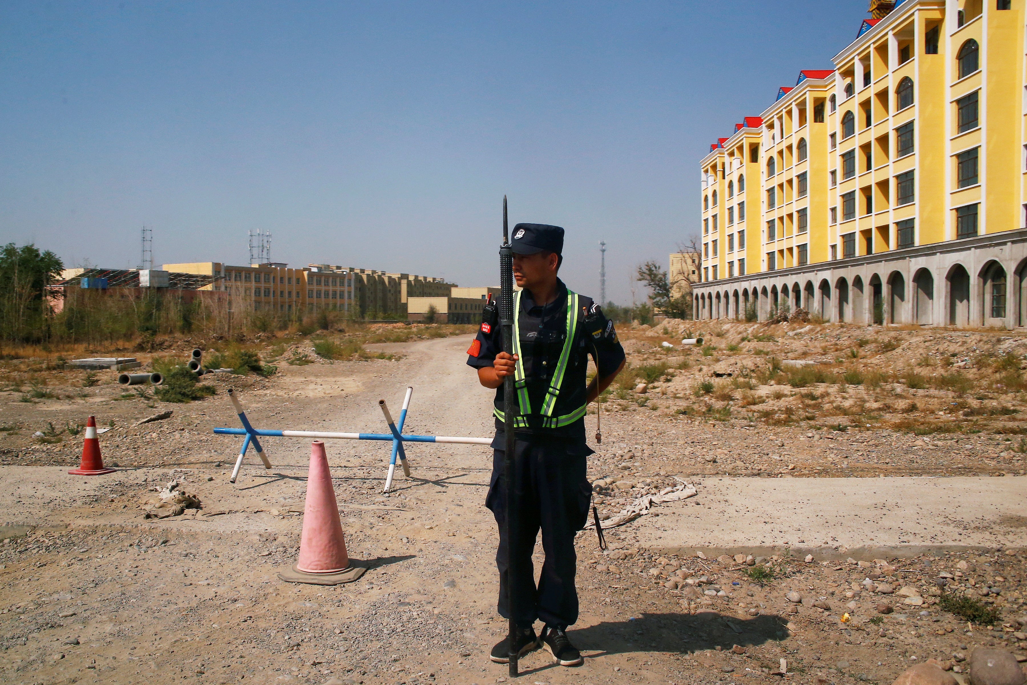 A Chinese police officer takes his position by the road near what is officially called a vocational education center in Yining in Xinjiang Uighur Autonomous Region