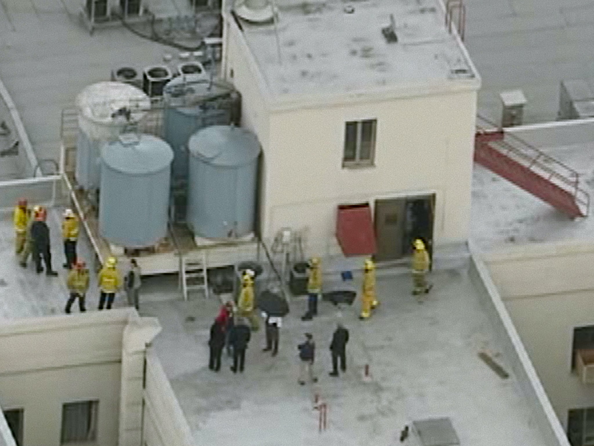 Firefighters and police officers on the roof of the Cecil Hotel